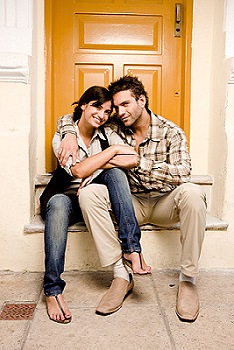Image of a couple sat on a step outside a property to illustrate prospective tenants.